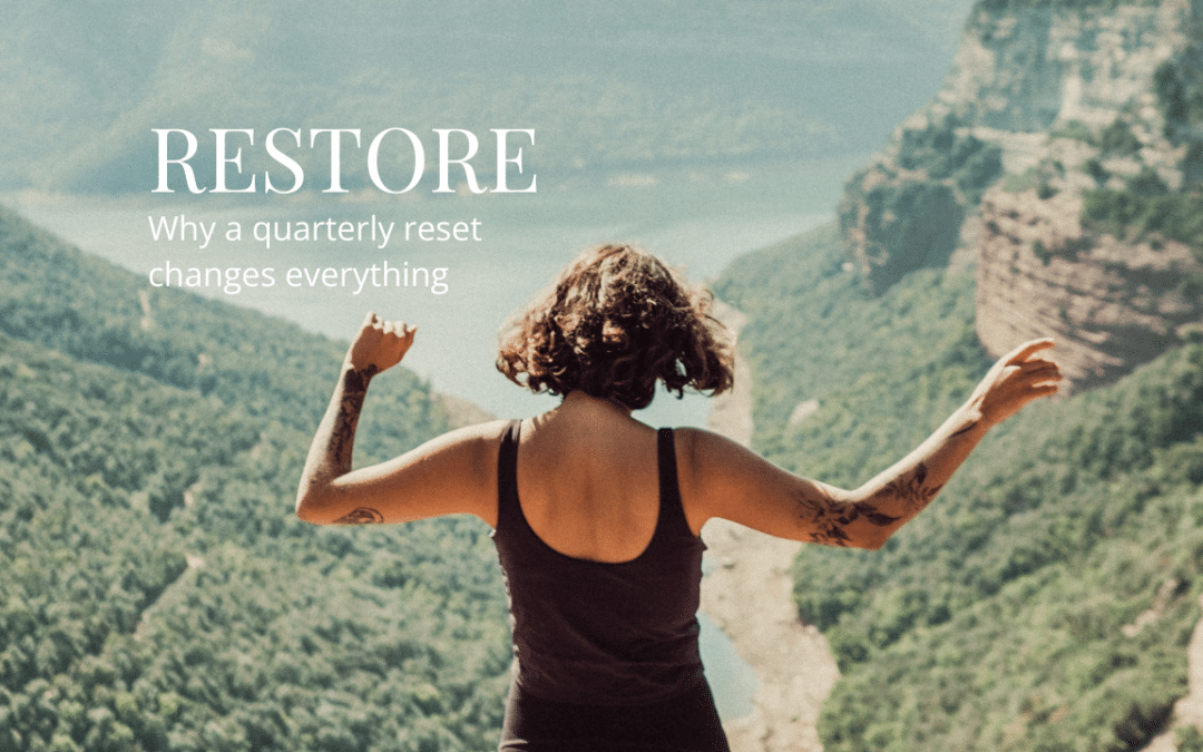 Woman standing at a scenic overlook with arms open, representing renewal and the perspective gained from a quarterly reset.