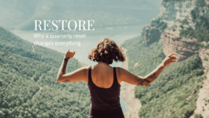 Woman standing at a scenic overlook with arms open, representing renewal and the perspective gained from a quarterly reset.